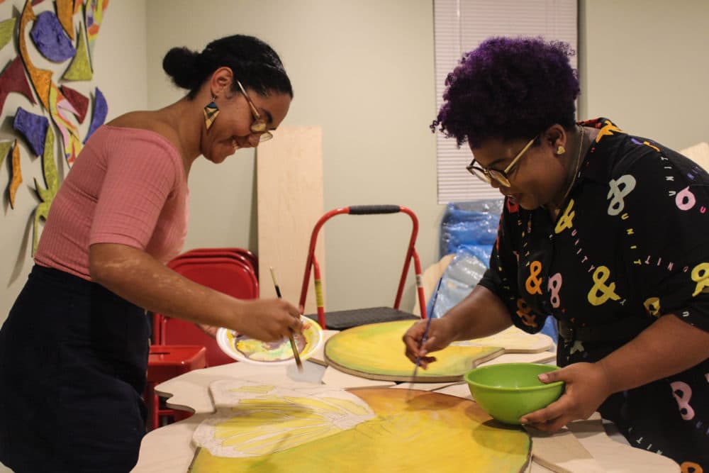 Artists Iris Lapaix and Chanel Thervil prepare for &quot;Mariposas and Mangos.&quot; (Arielle Gray for WBUR)