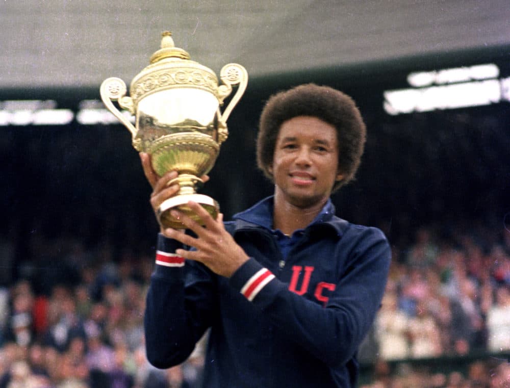 Arthur Ashe hoists the 1975 Wimbledon trophy after beating the highly favored Jimmy Connors. (AP Photo)