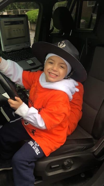 Cristopher Chavarria poses in the front seat of a police cruiser after a community walk in support of his family. (Courtesy Yohana Velasquez)