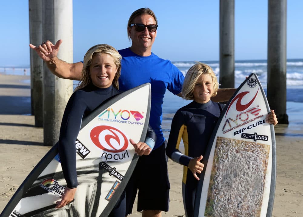 Peter Romaniuk takes his 8-year-old son Petey and 12-year-old daughter Julianna to Huntington Beach to catch some waves. Both of his kids have been surfing since they were two. (Chris Bentley/Here & Now)