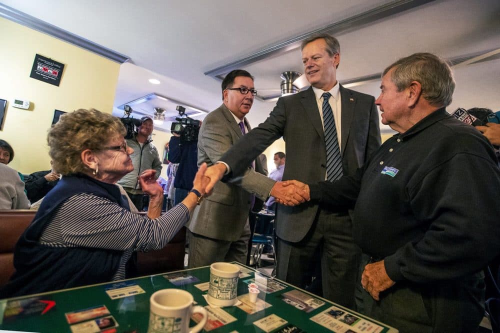 Baker shakes hands with a customer at the diner. (Jesse Costa/WBUR)