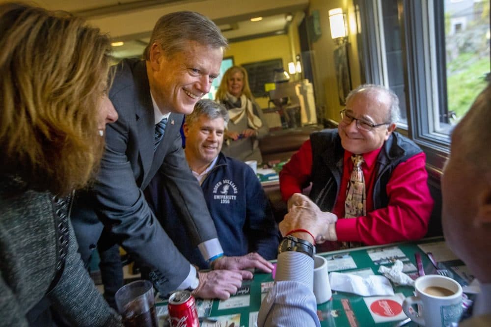 Baker and Lt. Gov. Karyn Polito chat with seated patrons at the diner. (Jesse Costa/WBUR)