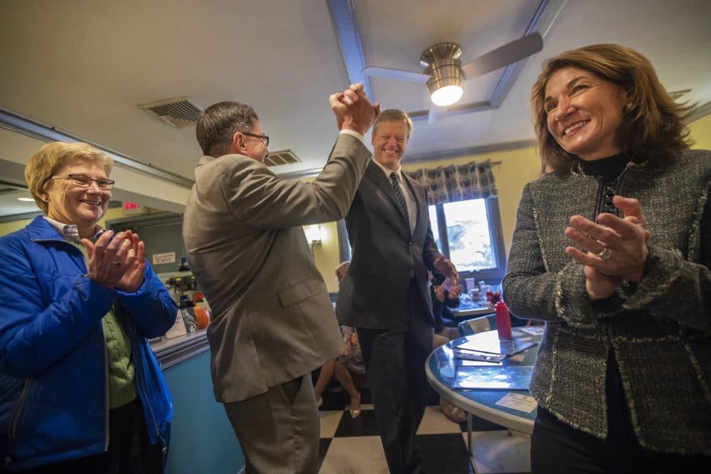 Gov. Charlie Baker high-fives Democratic state Rep. David Nangle at the Four Sisters Owl Diner in Lowell during his final day of campaigning ahead of Election Day. (Jesse Costa/WBUR)