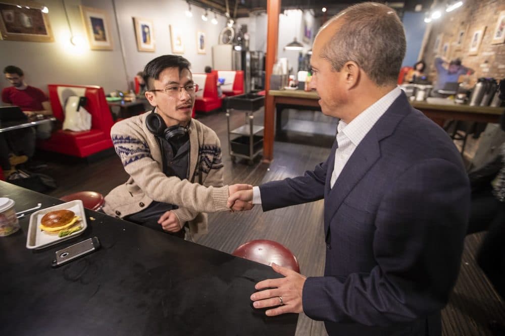 Jay Gonzalez introduces himself to Nick Mihmaich inside Diesel Coffee Shop in Davis Square in Somerville. (Jesse Costa/WBUR)