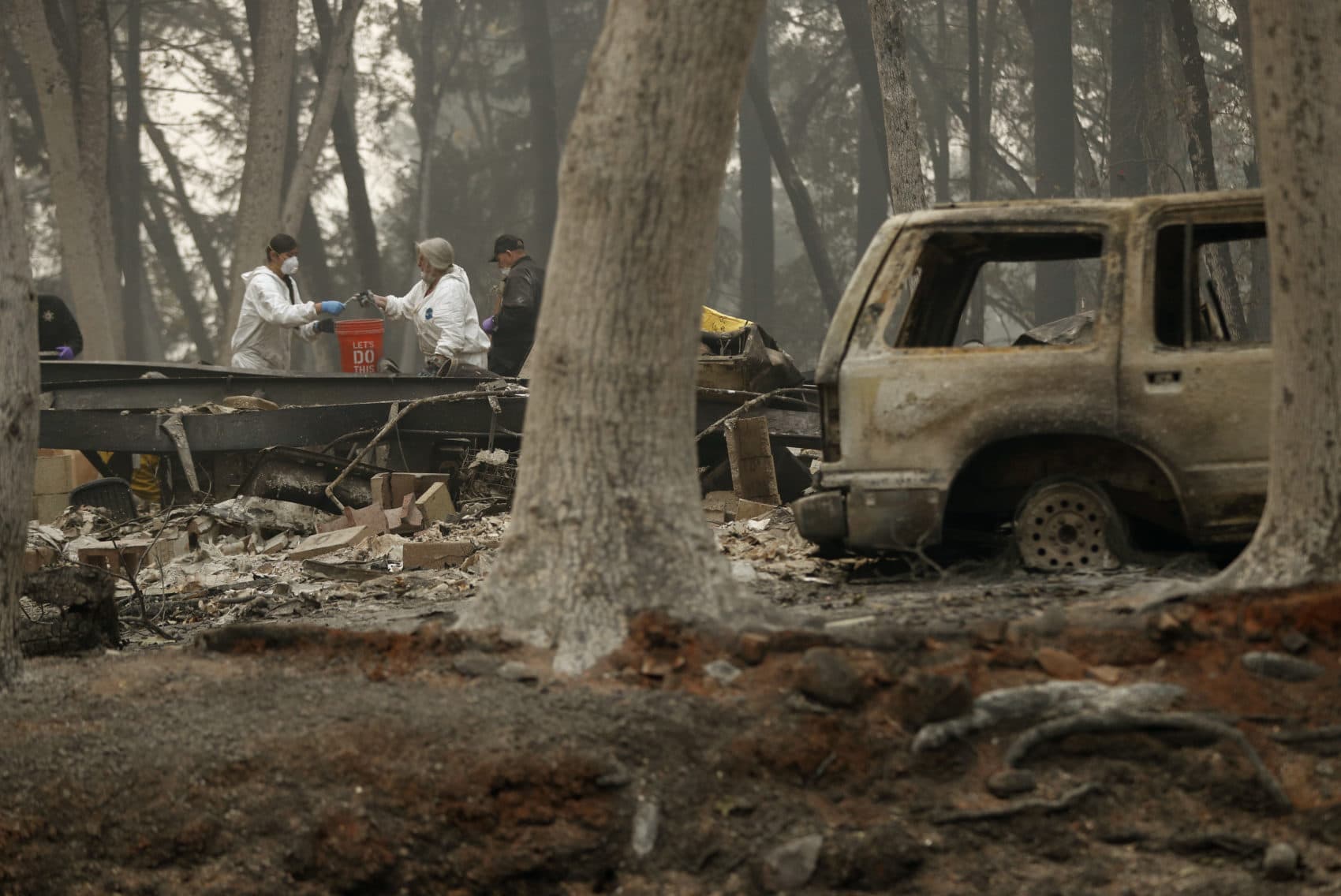 Investigators use a bucket to help recover human remains at a home burned in the Camp Fire, Thursday, Nov. 15, 2018, in Magalia, Calif. Many of the missing in the deadly Northern California wildfire are elderly residents in Magalia, a forested town of about 11,000 north of the destroyed town of Paradise. (John Locher/AP)