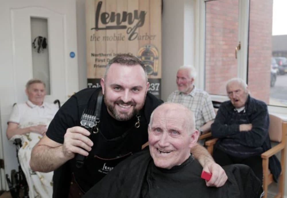 Lenny White smiles with a client during a haircut. (Courtesy)