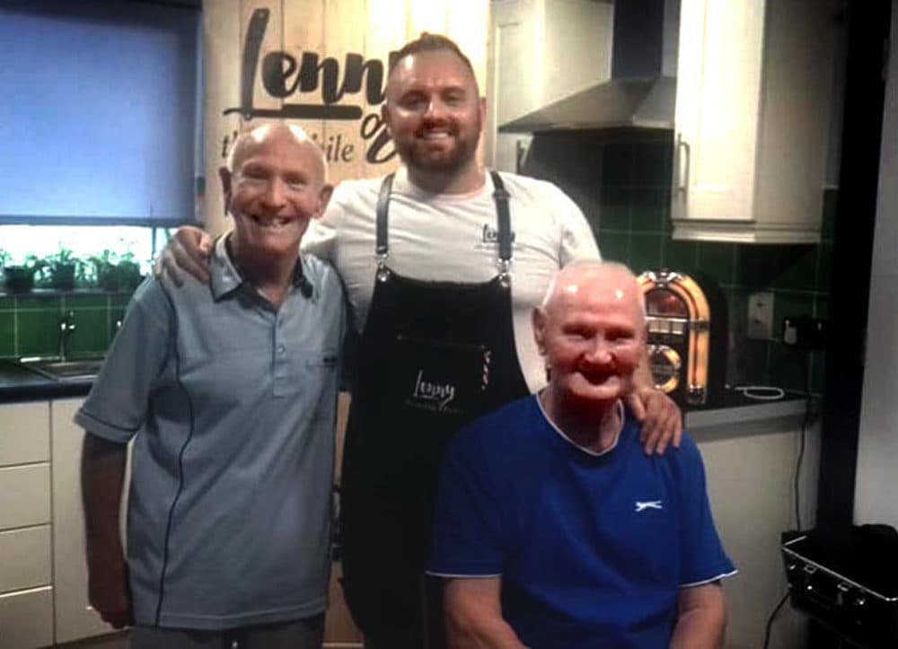 Jim Gray, right, poses with a friend for a post-haircut picture with barber Lenny White, center. (Courtesy Lenny White and Rhonda Robinson)