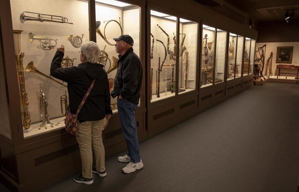 Visitors look at the MFA’s collection of rare musical instruments. (Robin Lubbock/WBUR)