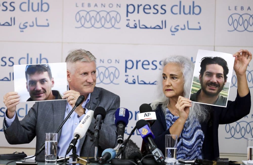 Marc and Debra Tice, parents of American journalist Austin Tice, who was kidnapped in Syria in 2012, hold up photos of their son in Beirut on July 20, 2017. (Joseph Eid/AFP/Getty Images)