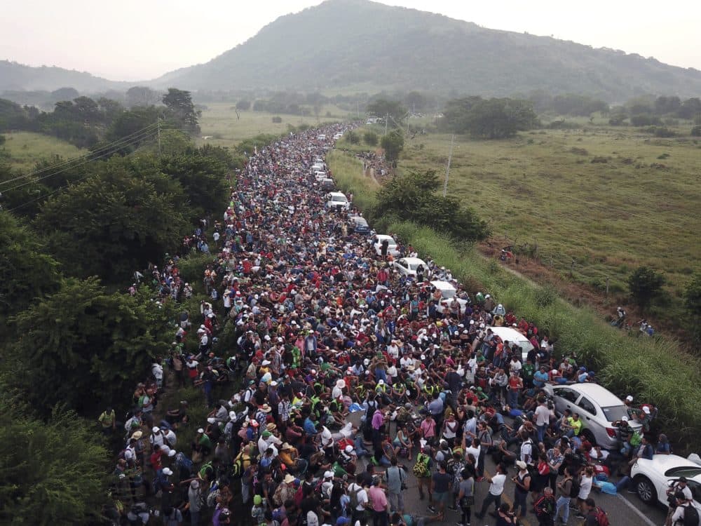 Members of a U.S.-bound migrant caravan stand on a road after federal police briefly blocked their way outside the town of Arriaga in Mexico on Oct. 27. (Rodrigo Abd/AP)