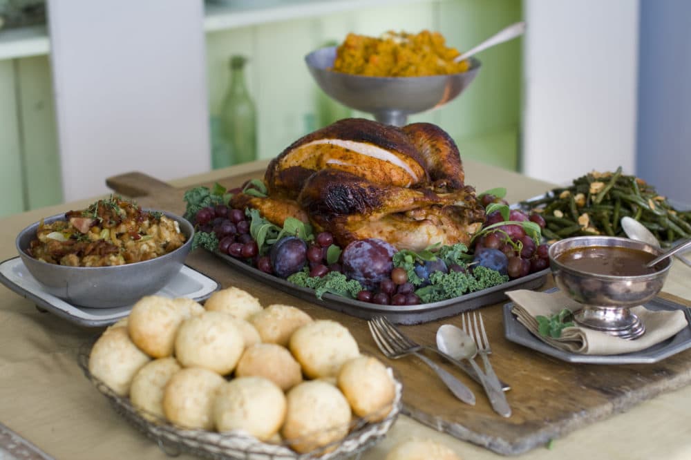 This Oct. 17, 2011 photo shows a sweet and spicy turkey surrounded by, clockwise from top, smashed harvest vegetables, oven-candied green beans amandine, gravy, brown sugar and oatmeal rolls and candied bacon stuffing in Concord, N.H. (AP Photo/Matthew Mead)
