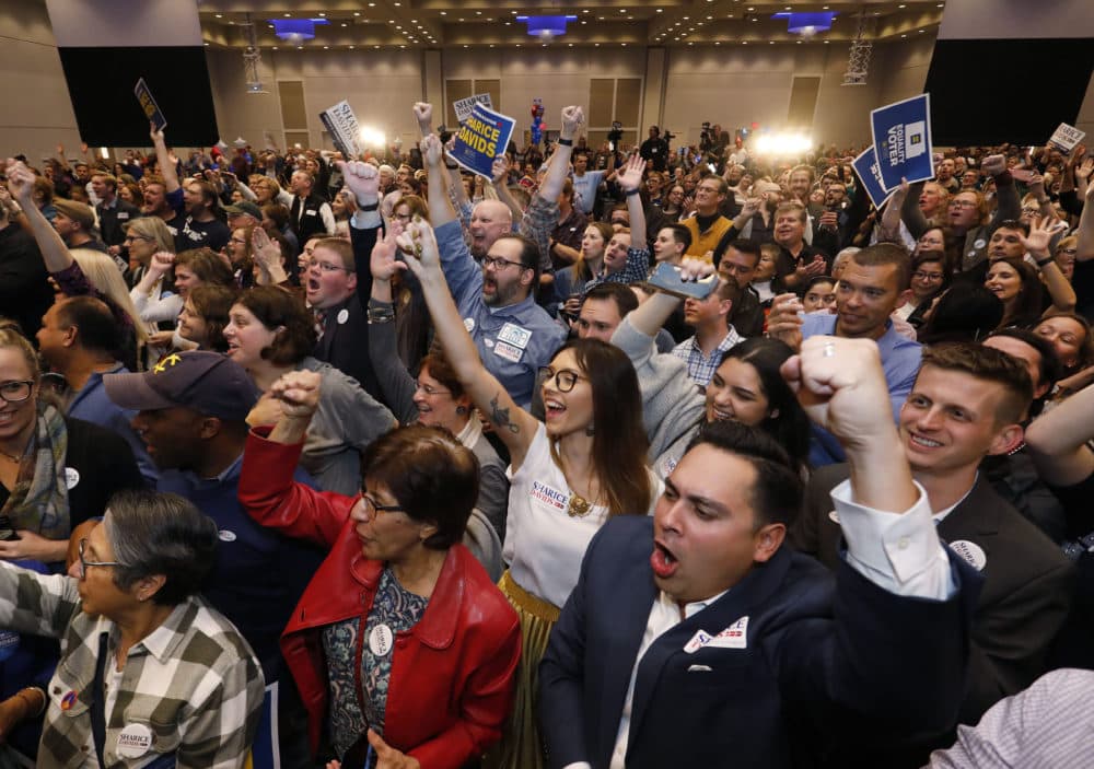 Supports for Democratic house candidate Sharice Davids react as newscasts declare their candidate the winner during a watch party in Olathe, Kan., Tuesday, Nov. 6, 2018. Davids defeated incumbent Republican U.S. Rep. Kevin Yoder for the Kansas 3rd Congressional District seat. (Colin E. Braley/AP)