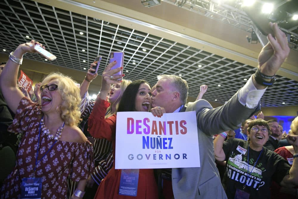 Supporters Ramona Cabrera, left, Rosemary Zore, center, and Mike Randall celebrate as a television broadcast declares Florida Gov.-elect Ron DeSantis the winner of the Florida gubernatorial race at a DeSantis election party Tuesday, Nov. 6, 2018, in Orlando, Fla. (Phelan M. Ebenhack/AP)