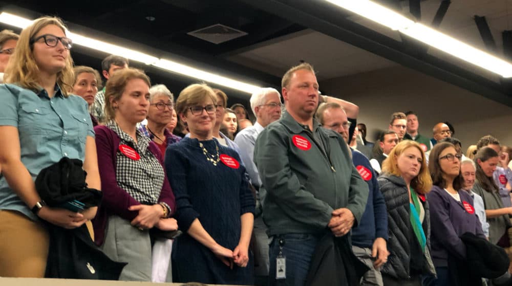 Newton community members stood in support of teachers at this week's meeting. (Max Larkin/WBUR)