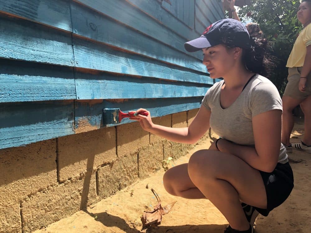Maria Figueroa paints a home as part of a trip to the Dominican Republic. (Courtesy, Summer Search)