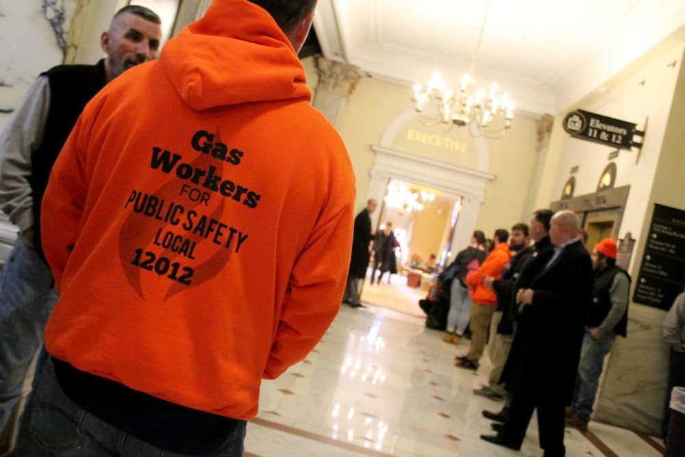 Locked out National Grid workers and their union presidents gathered in the hallway outside Gov. Charlie Baker's office after the Legislature sent Baker a bill to extend the gas workers' unemployment benefits. (Sam Doran/SHNS)