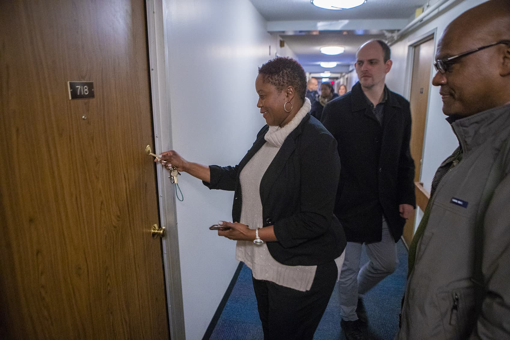 Property manager Monica Daniel puts the key into the door of Brian DeSilva's new studio apartment. (Jesse Costa/WBUR)