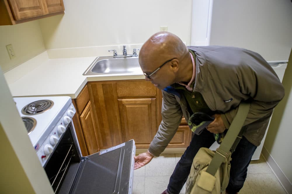 DeSilva checks the oven in his new apartment. (Jesse Costa/WBUR)