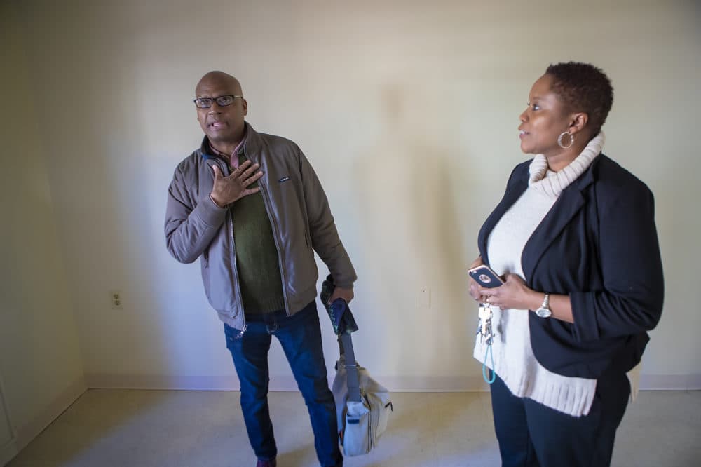 Brian DeSilva stands in his studio apartment with Monica Daniel, the property manager. (Jesse Costa/WBUR)