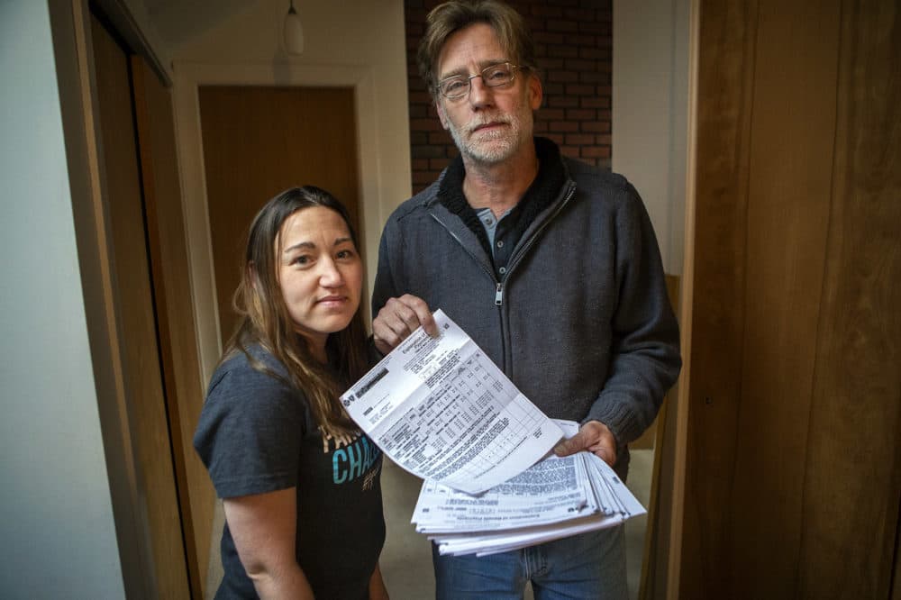 Kristina Cunningham is seen with her dad, Jim Royer, who holds her MedFlight bill totaling hundreds of thousands of dollars. (Jesse Costa/WBUR)