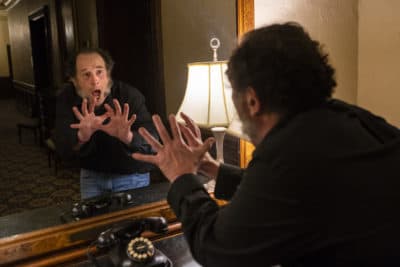 Actor Jeremiah Kissel recites a few lines from &quot;A Christmas Carol&quot; in the mirror used by Charles Dickens for rehearsals during his stays at the Omni Parker House. (Jesse Costa/WBUR)