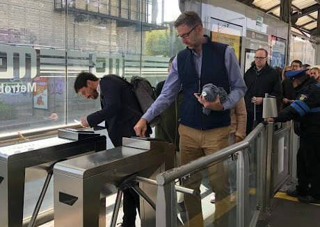Will Foley of Cushman & Wakefield and Dave McLaughlin of WeWork scan their bus passes to enter the boarding area for a line of the Metrobus in Mexico City. (Courtesy Alliance for Business Leadership)