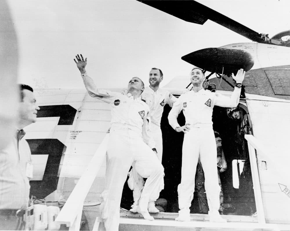 Crew members of Apollo 8 wave as they leave the recovery helicopter. From left, Frank Borman, commander; James Lovell, Command Module (CM) pilot; William Anders, Lunar Module (LM) Pilot. The three safely returned to Earth on Dec. 27, 1968. (Courtesy WGBH/NASA)