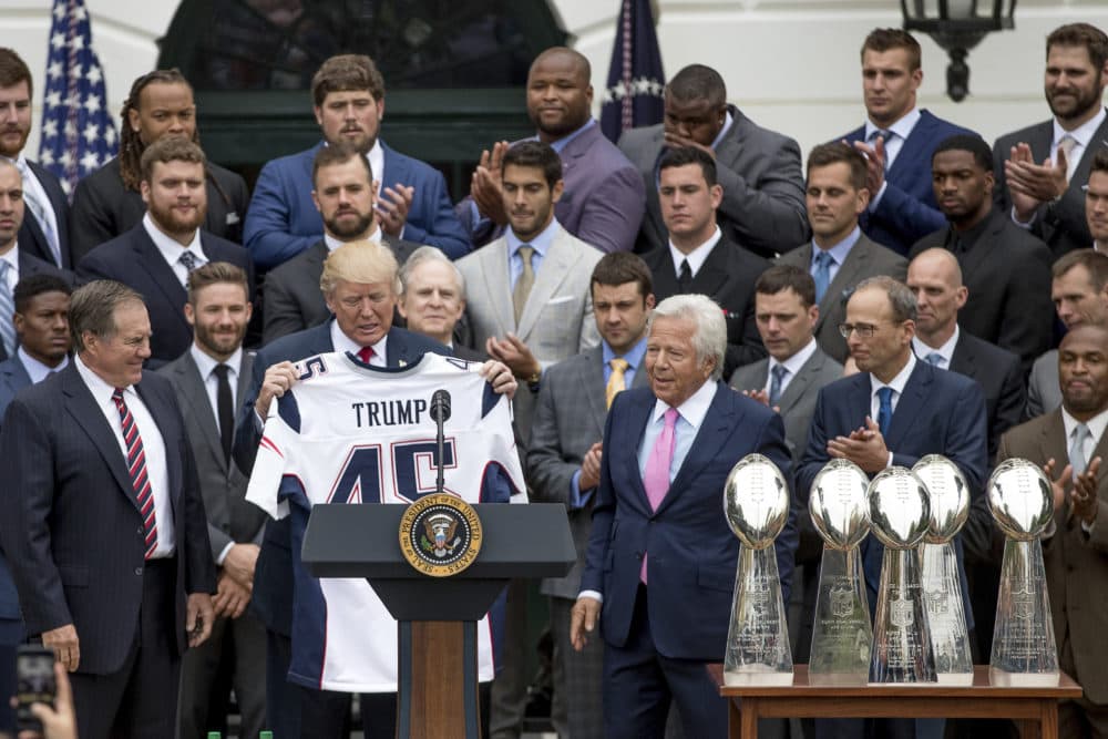 President Trump is presented with a New England Patriots jersey by head coach Bill Belichick, left, and owner Robert Kraft, center, during a ceremony at the White House on April 19, 2017, where the president honored Pats for their Super Bowl LI victory. (Andrew Harnik/AP)