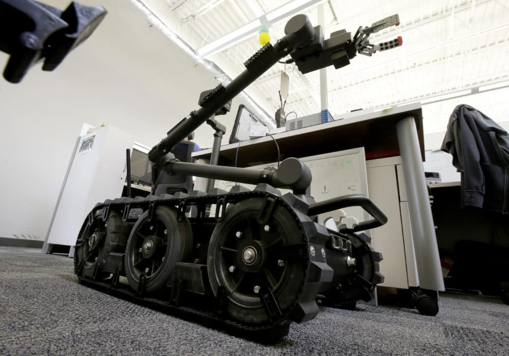In this Aug. 28, 2018 photo a Centaur robot rests on a carpeted floor between desks at Endeavor Robotics in Chelmsford, Mass. The Army is looking for a few good robots. These robots won’t fight, at least not yet. But they will be designed to help the men and women who do. The companies making them are waging a different kind of battle. At stake is a contract worth almost half a billion dollars for 3,000 backpack-sized robots that can defuse bombs and scout enemy positions. (Steven Senne/AP)