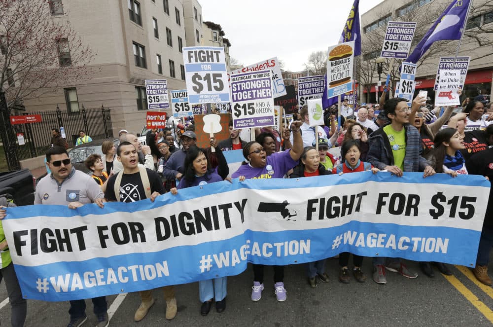 Fast-food restaurant employees and other workers marched in a "Fight for 15" demonstration in Boston in 2015. The Massachusetts minimum wage will rise to $12.75 per hour on Jan. 1 and gradually increase to $15 per hour in 2023. (Steven Senne/AP)