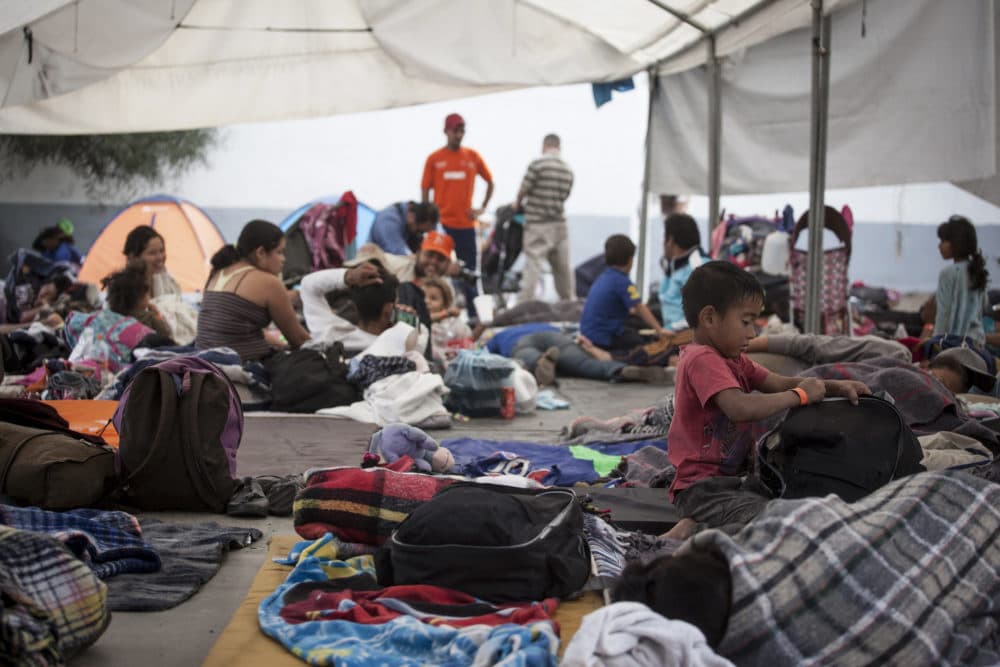 Central American migrants rest in a temporary shelter Tijuana officials opened at the Unidad Deportiva Benito Juárez sports center on Nov. 15, 2018. Many say they are fleeing gang violence in their home countries. (Erin Siegel McIntyre/KQED)