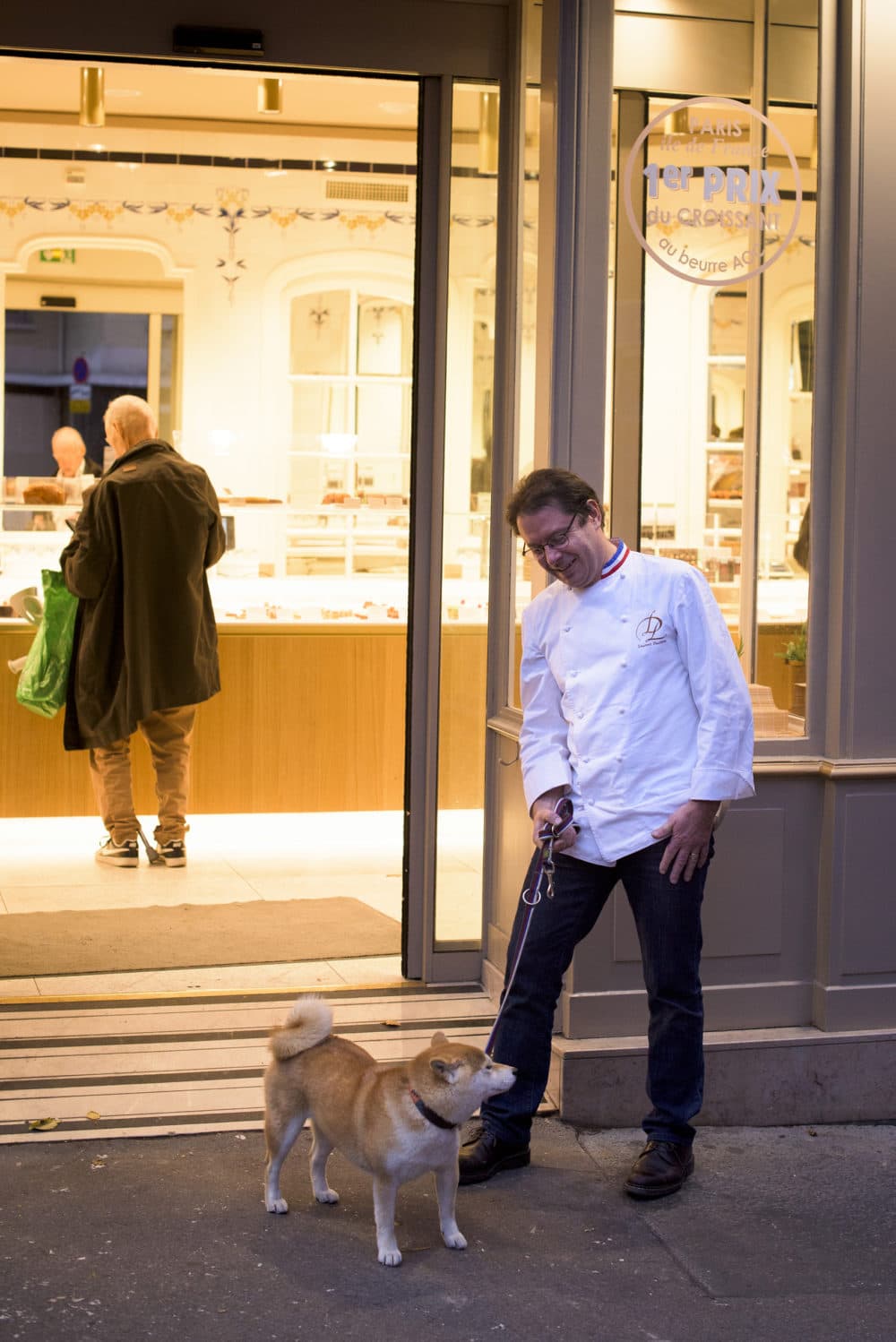 Laurent Duchne, who has been decorated as one of France's top pastry makers, watches a patron's dog, who is named Jacynthe, outside his boutique in the 13th Arrondissement on Nov. 12, 2018 in Paris. (Pete Kiehart for Here &amp; Now)