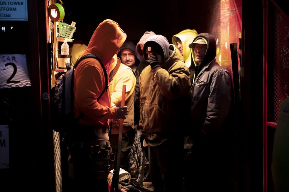 Construction workers load into a freight elevator to begin work in the early morning hours. (Jesse Costa/WBUR)