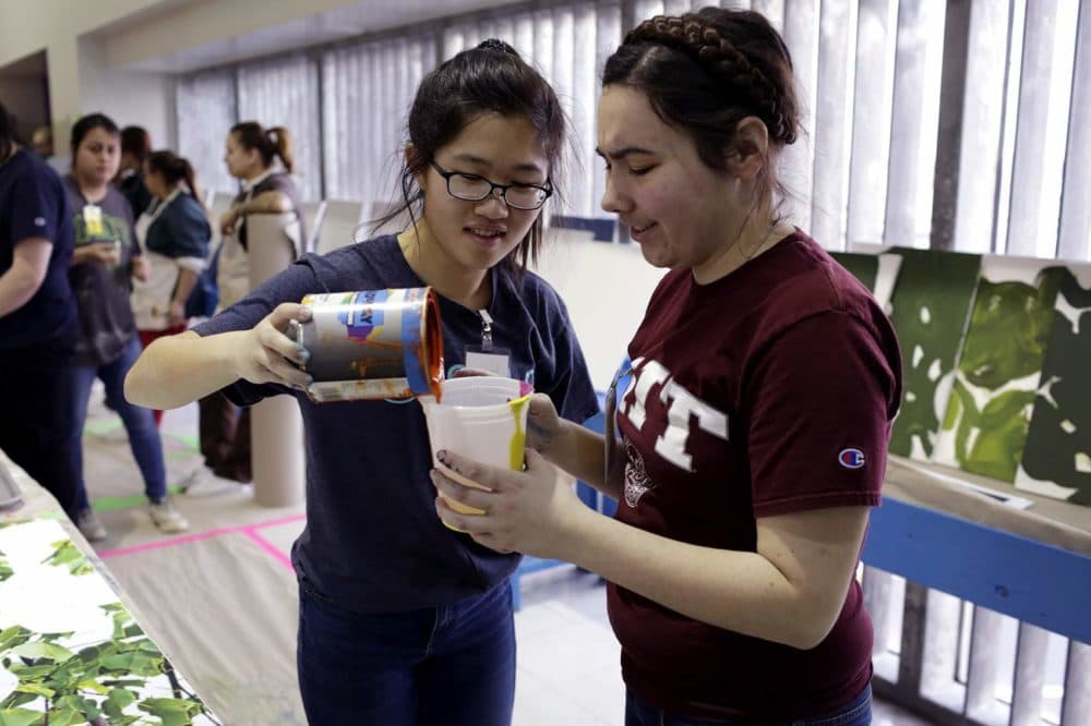 Sherry Xiao, an MIT freshman, and Helen Read, an MIT junior, pour paint. (Hadley Green for WBUR)