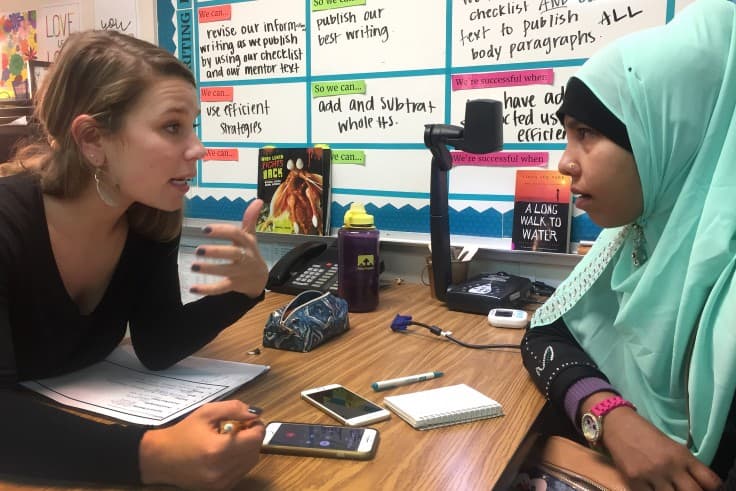 Kenton Elementary fifth grade teacher Gracie Binder talks with Husanara Makbulhussin about her daughter Siti’s academic progress at a parent teacher conference. (Jenny Brundin/CPR News)