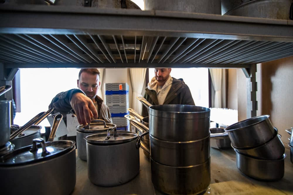Chris and Jared Palladino of Willy’s Ale Room in Acton, Maine, check out some saucepans on a shelf. (Jesse Costa/WBUR)
