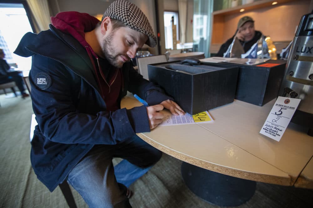Devon Trevelyan of Knight Moves Cafe in Brookline fills out his auctioneer card before the auction. (Jesse Costa/WBUR)