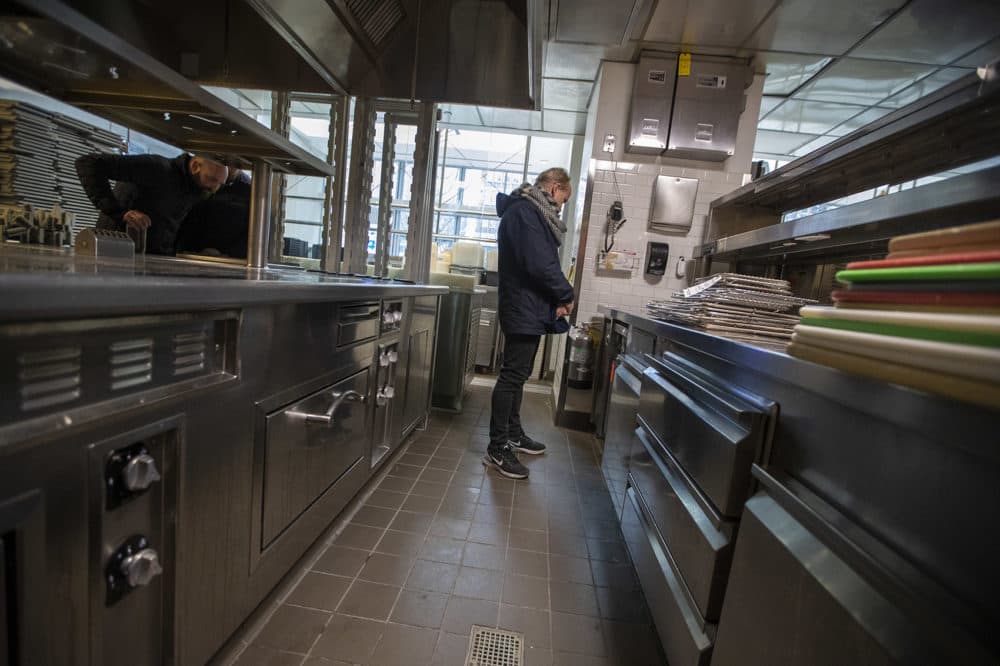 A man checking out the refrigerator cabinet at the L’Espalier auction. (Jesse Costa/WBUR)