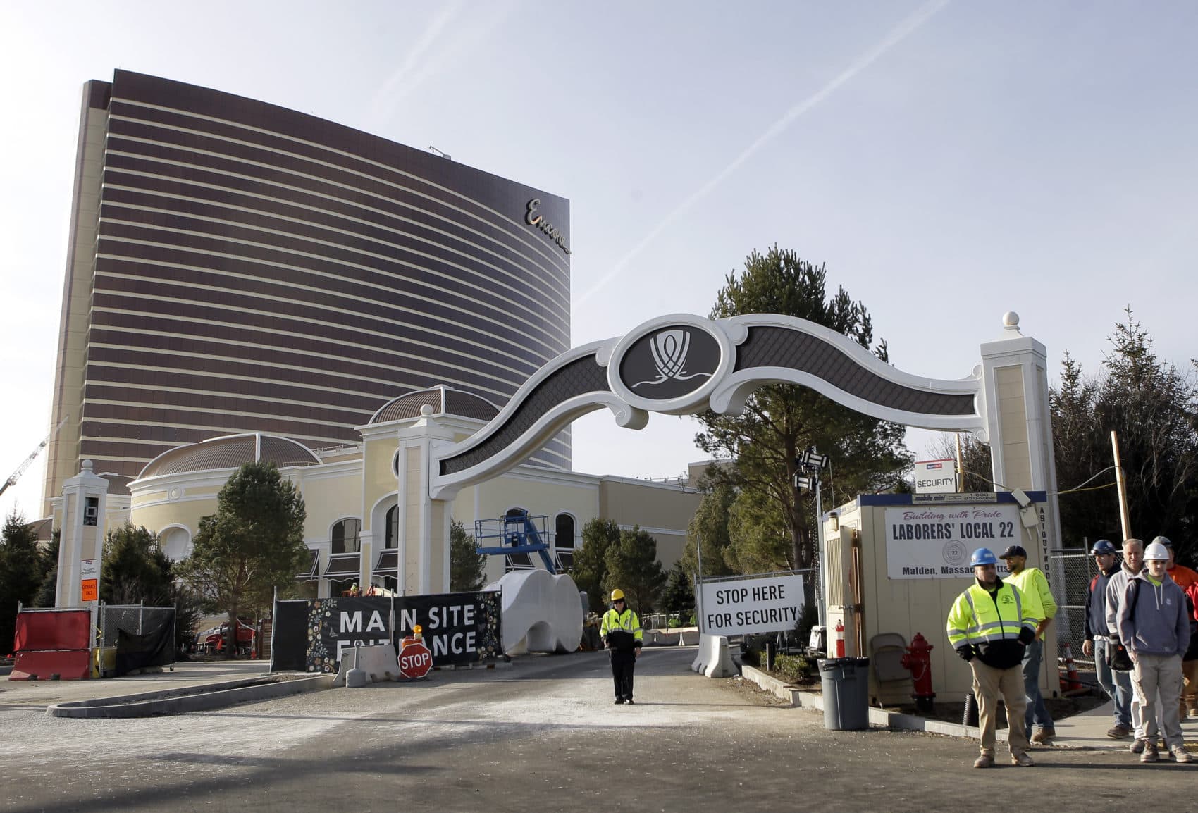 Workers stand near an entrance to the under-construction Encore Boston Harbor luxury resort and casino, in Everett, Mass., on Jan. 2, 2019. (Steven Senne/AP)