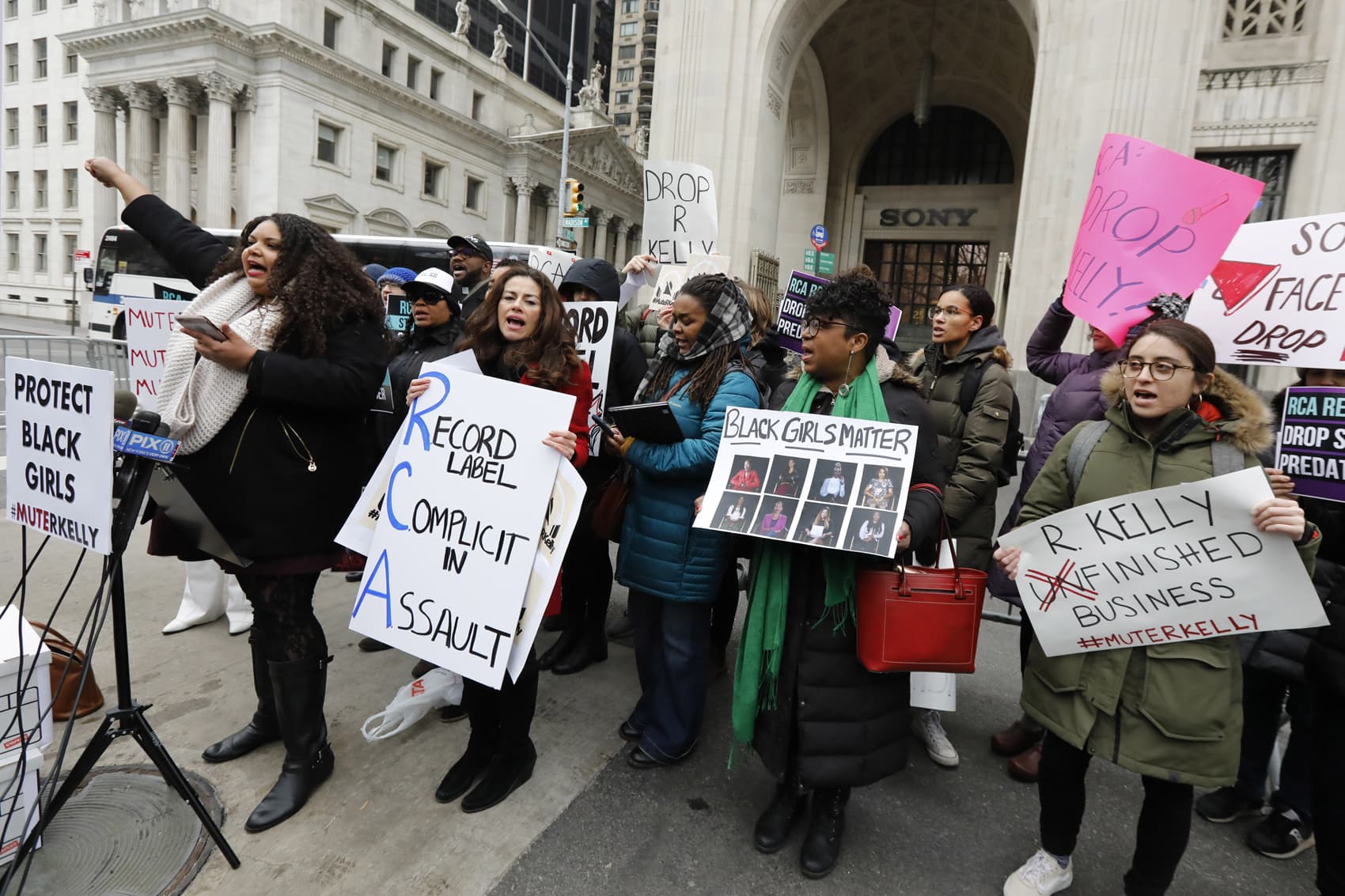 Sonja Spoo, left, associate campaign director of Ultra Violet, leads chants during an R. Kelly protest outside Sony headquarters, in New York, Wednesday, Jan. 16, 2019. Kelly has been under fire since the recent airing of a Lifetime documentary "Surviving R. Kelly ." He has denied all allegations of sexual misconduct involving women and underage girls. (Richard Drew/AP)