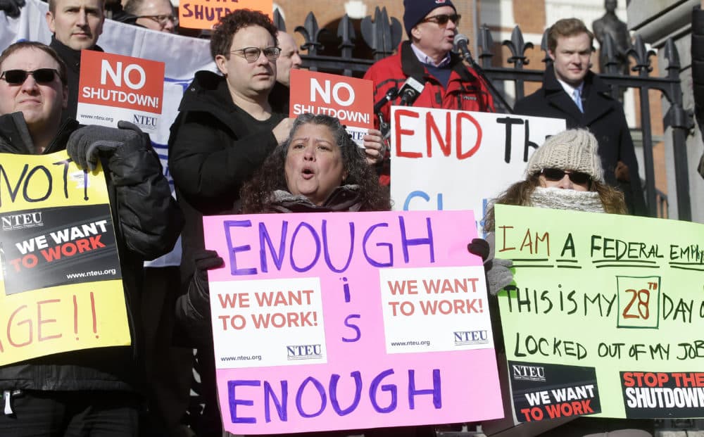 Internal Revenue Service employees display placards during a rally by federal employees and supporters on Jan. 17 in front of the State House in Boston. (Steven Senne/AP)