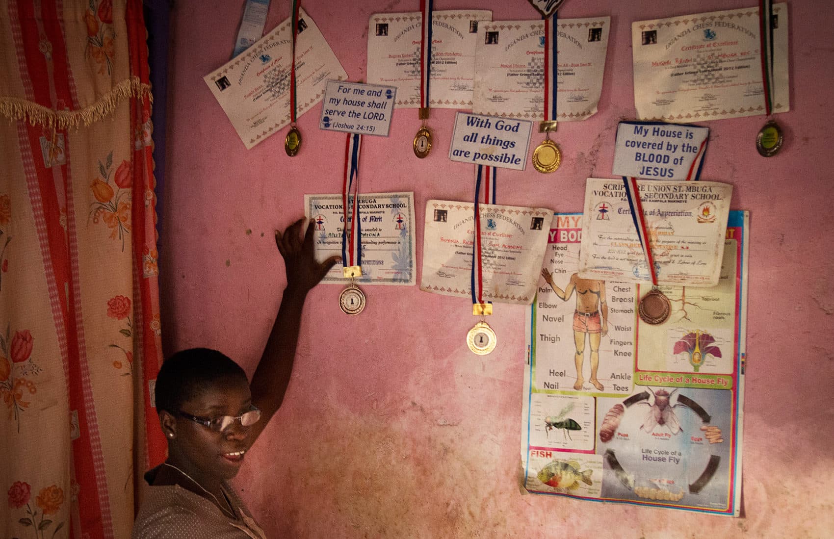Phiona Mutesi poses with her wall of chess accolades. (Michele Sibiloni/AFP/Getty Images)