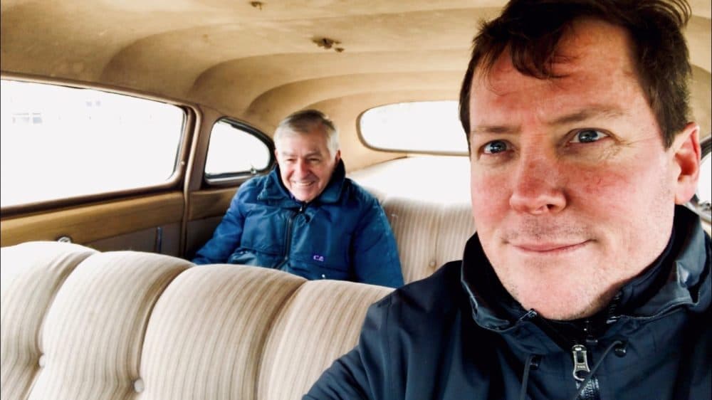 The author, Dan McNichol, is pictured with Governor Dukakis, who is riding in the back of his car. (Courtesy)