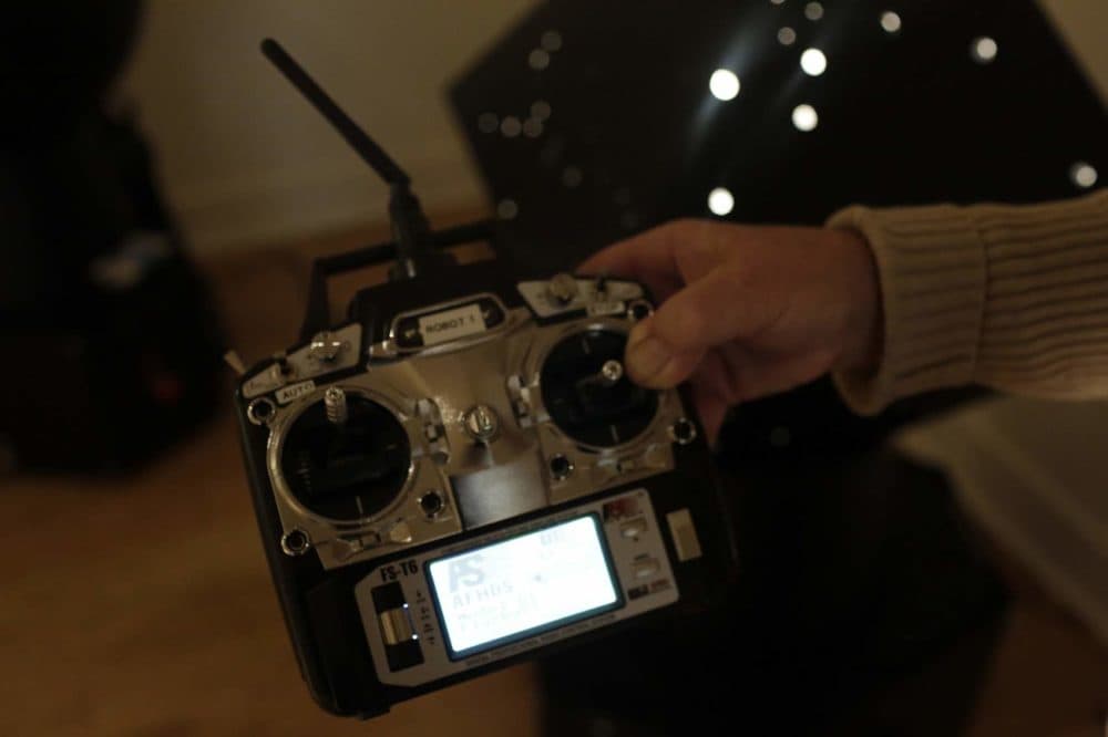 John Powell holds the control for Otto Piene's light robots at the Fitchburg Art Museum. (Hadley Green for WBUR)