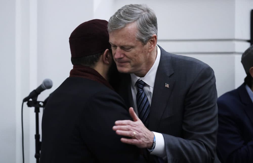 Massachusetts Gov. Charlie Baker, right, embraces Senior Imam Yasir Fahmy during the prayer service. (Charles Krupa/AP)