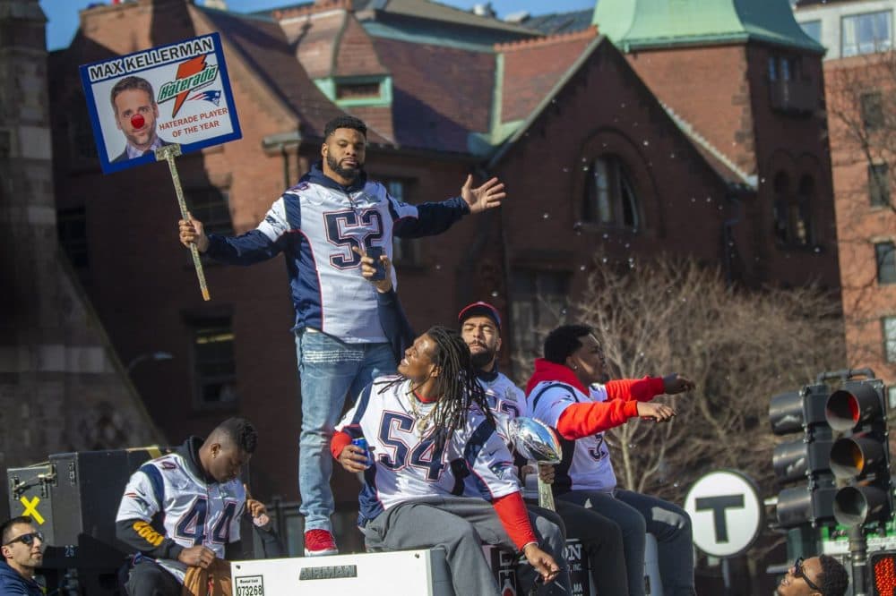 Elandon Roberts (52) holds up a sign with ESPN host Max Kellerman with a clown nose as fellow linebackers Dont'a Hightower (54), Kyle Van Noy (53) and Ja'Whaun Bentley (51) enjoy the celebration. (Jesse Costa/WBUR)
