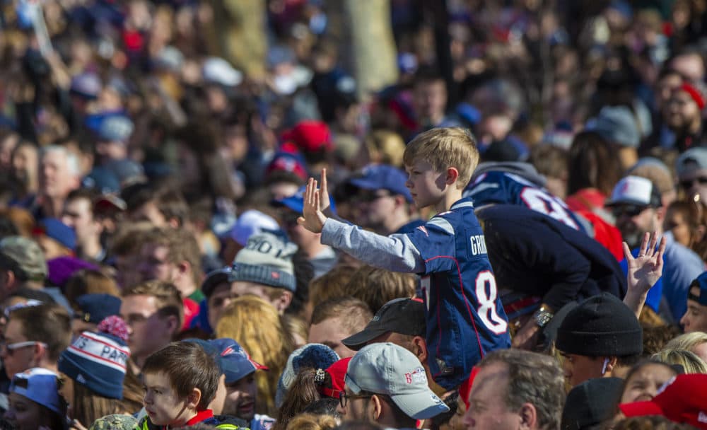 A young boy holds up six fingers symbolizing six championships. (Jesse Costa/WBUR)