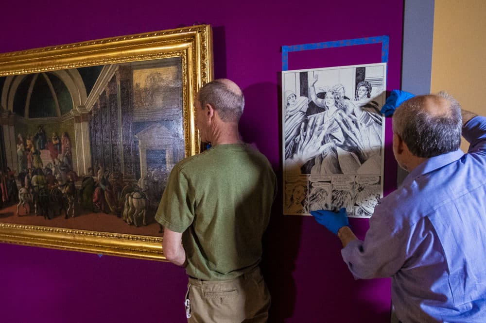 Preparators at the Isabella Stewart Gardner Museum hang &quot;The Story of Virginia.&quot; Next to the painting, a preparator adjusts a drawing by award-winning graphic novelist Karl Stevens, who reimagined the paintings in a contemporary idiom: the cartoon (Jesse Costa/WBUR)
