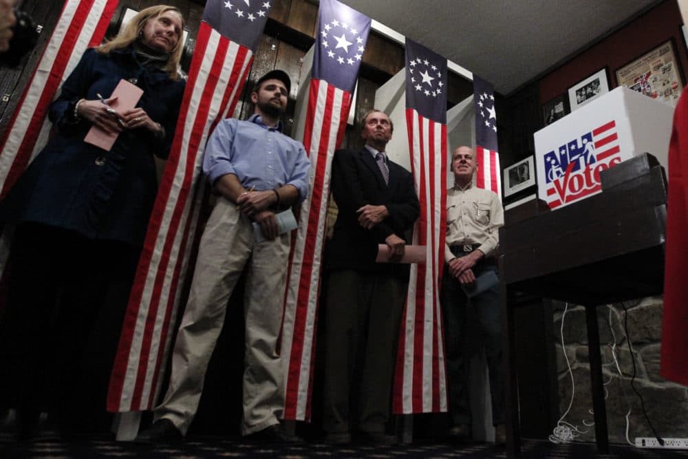 From left, Donna Kaye Erwin, Tanner Tillotson, Peter Johnson, and Jacques Couture wait for the stoke of midnight to cast their voters in the first-in-the-nation presidential primary at The Balsams Grand Resort in 2012. (Matt Rourke/AP)