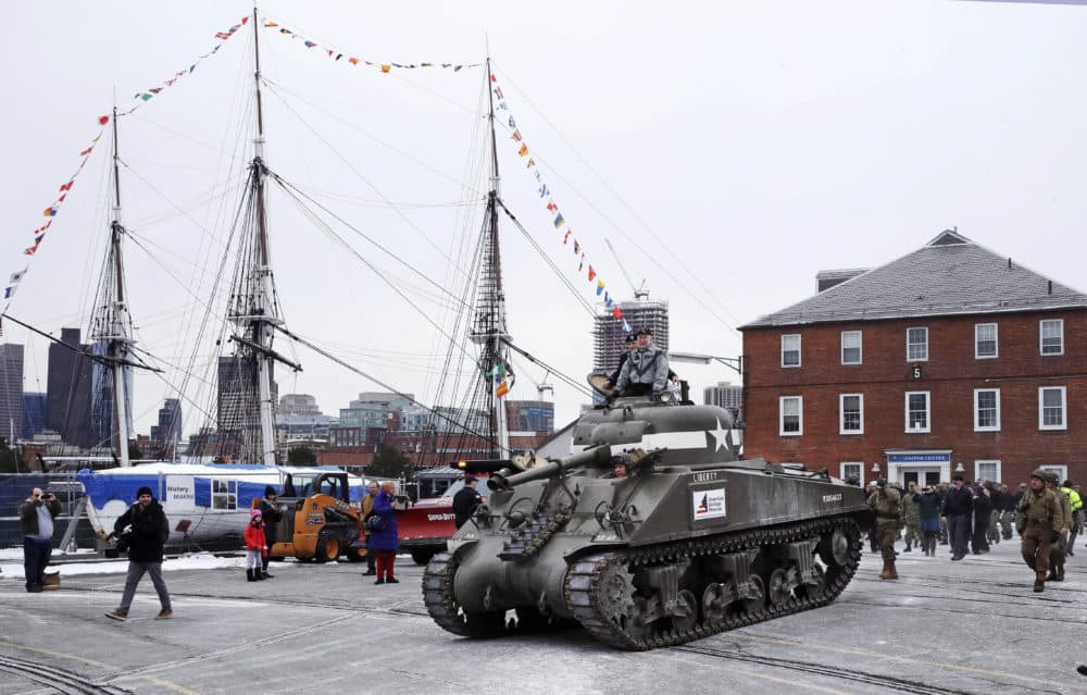 World War II tank gunner Clarence Smoyer sits atop a tank as he passes the historic frigate U.S.S. Constitution at the Charlestown Naval Shipyard in Boston. (Charles Krupa/AP)